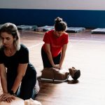 Duas pessoas a praticar técnicas de reanimação em manequins de treino de primeiros socorros