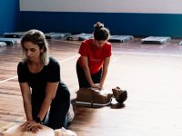 Duas pessoas a praticar técnicas de reanimação em manequins de treino de primeiros socorros